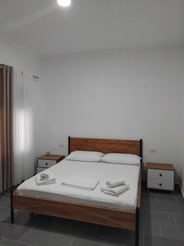 a bedroom with a bed with white sheets and pillows at Vila Rei in Borsh