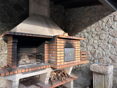 einen Backsteinofen im Freien neben einer Steinmauer in der Unterkunft Casa da Forja - Gerês in Gondoriz