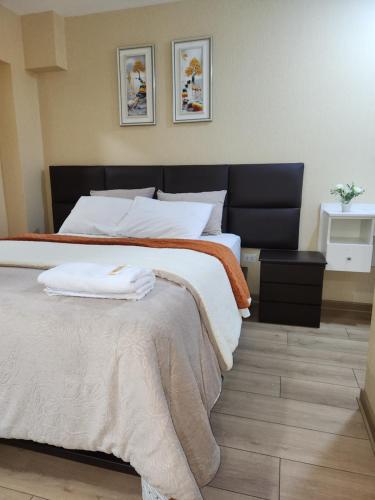 a bedroom with a large bed with two towels on it at Vive y descansa con seguridad a 3min del mall San Miguel in Lima