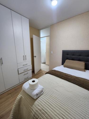 a bedroom with a bed with a roll of toilet paper on it at Vive y descansa con seguridad a 3min del mall San Miguel in Lima