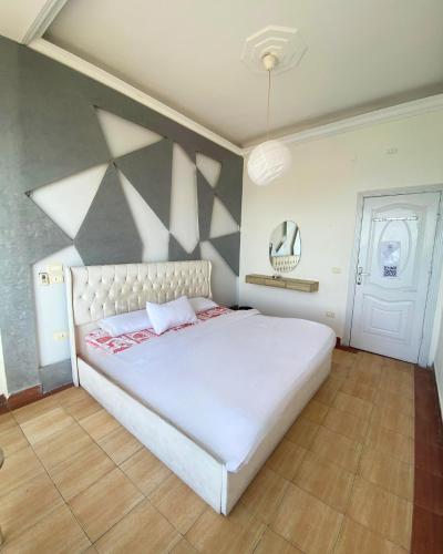 a bedroom with a white bed and a wall with stars at Hayah Suites & Rooms in Alexandria