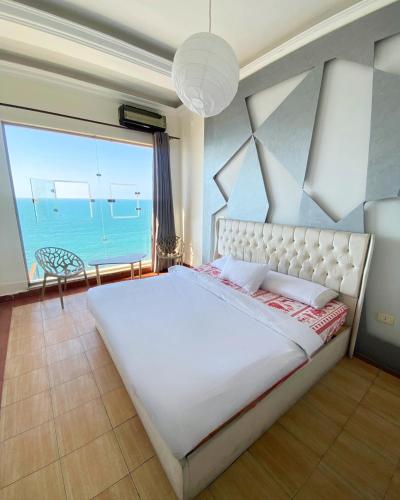 a bedroom with a large bed with a view of the ocean at Hayah Suites & Rooms in Alexandria