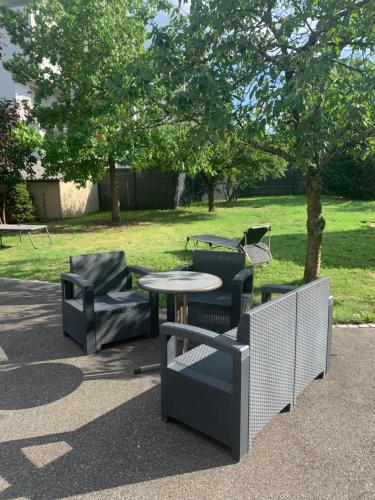 two chairs and a table and a table and chairs at Le repos des escargots - Appartement classé 1 à 6 personnes avec jardin ombragé et aménagé in Haguenau