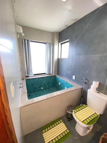 a bathroom with a bath tub and a toilet at Loft com vista p o mar em arraial in Arraial do Cabo
