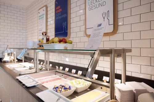 a buffet line in a restaurant with some food at Holiday Inn Express & Suites Monheim am Rhein by IHG in Monheim
