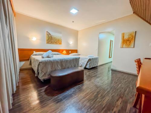 a hotel room with two beds and a window at Hotel Nacional Inn Campos do Jordão in Campos do Jordão