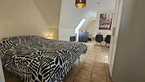 a bedroom with a black and white bed and a table at Villa Gottem in Deinze