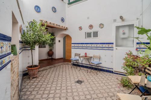Zimmer mit blauen und weißen Wänden sowie einem Tisch und Stühlen in der Unterkunft Calleja La Pimentera in Córdoba