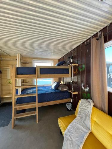 a bedroom with two bunk beds and a couch at Hébergement Parc du Mont Saint-Mathieu in Saint Mathieu de Rioux
