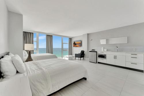 Un dormitorio blanco con una cama grande y una cocina. en Ocean Manor Beach Resort, en Fort Lauderdale