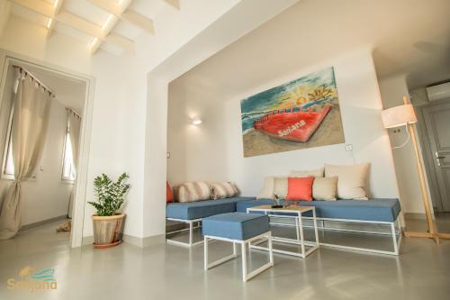 a living room with a blue couch and a painting at Santana Beach in Agia Anna Naxos