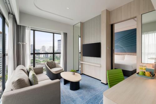 a hotel room with a couch and a bed at Holiday Inn Kuala Lumpur Bangsar by IHG in Kuala Lumpur