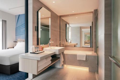 a bathroom with a sink and a bed and a mirror at Holiday Inn Kuala Lumpur Bangsar by IHG in Kuala Lumpur