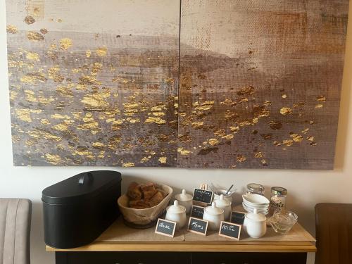 een tafel met een kom met eten en een schilderij bij La Plordonnière in Mornac-sur-Seudre