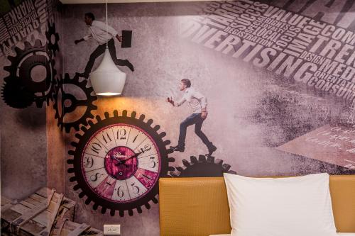 a mural of a man running behind a clock at The Cloud Hotel Zhongli Branch in Zhongli