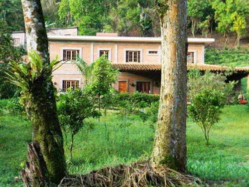 a house in the middle of a field with trees at Finca Eco Turística Aguas del Arenal 