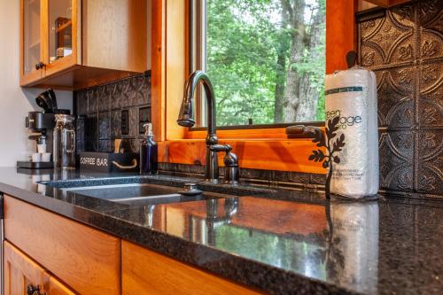 a kitchen counter with a sink and a window at Chasing Sunsets: A Cozy 2-Bedroom Cabin in Smoky Mts with Stunning Mountain Views. in Whittier