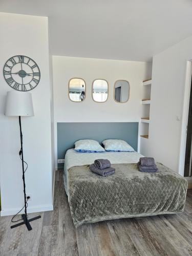 une chambre avec un lit et une horloge au mur dans l'établissement Appartement climatisé avec balcon,wifi, proche remparts, à Avignon