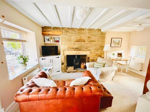 a living room with a couch and a fireplace at Fox Cottage - Cosy Stay on Pateley High Street in Pateley Bridge