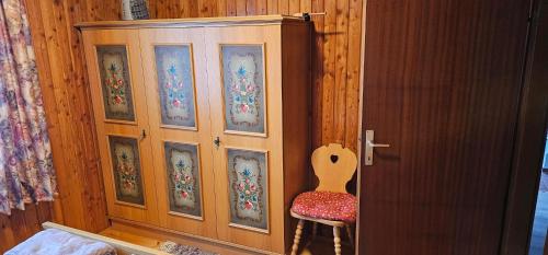 a wooden cabinet with a chair next to a door at Ferienhaus Anna in Weitenbach