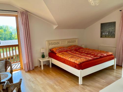 ein Schlafzimmer mit einem Bett und einem großen Fenster in der Unterkunft Chalet Attersee - ganzes Ferienhaus, Seeblick, Kamin, Sauna in Nussdorf am Attersee