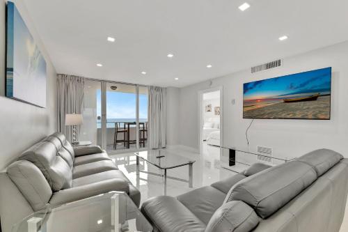 a living room with couches and a flat screen tv at Ocean Manor Beach Resort in Fort Lauderdale
