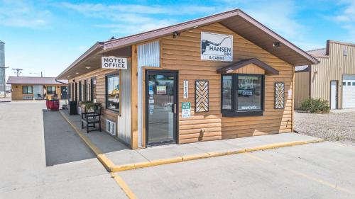 a small wooden building with a sign on it at Hansen Inn & Cabins in Wall