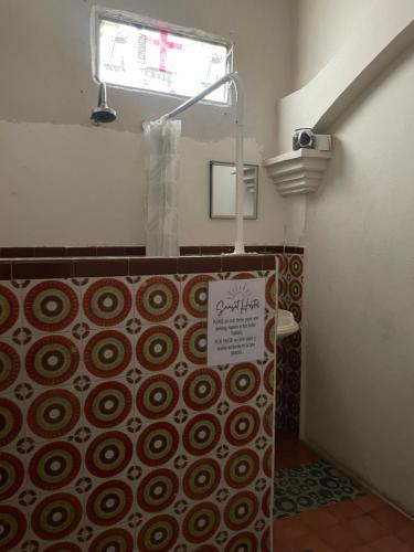 a bathroom with a shower with a sign on the wall at Sunset Hostel - Centro - in La Paz