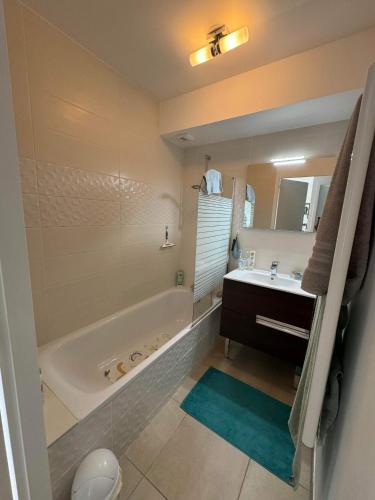 une salle de bain avec une baignoire et un lavabo dans l'établissement Bel appartement proche du lac, à Duingt
