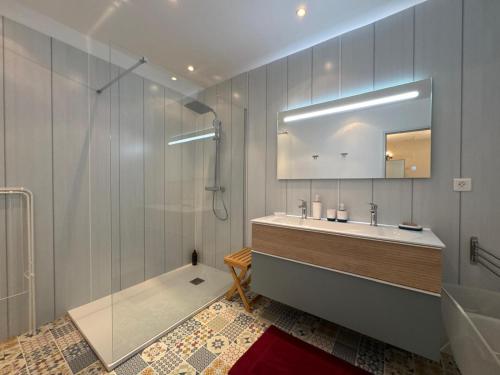 un bagno con vasca, lavandino e specchio di Côté Place - Appartement centre a Saint-Martin-de-Bréthencourt