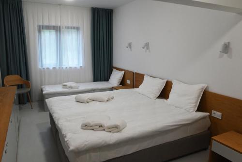 two beds in a hotel room with towels on them at Hotel Etar in Gabrovo