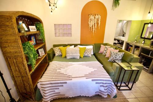 a living room with a green couch with pillows at Casa Verdejo - Zona Romantica in Puerto Vallarta