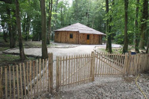 une clôture en bois devant une cabane en bois dans l'établissement L'isba des bois, hors du temps, à Janvry
