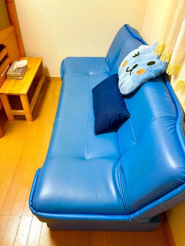 a blue leather couch in a living room at 覚羅中央区別荘101室 in Chiba