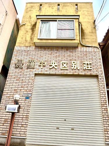 a building with a garage door and a window at 覚羅中央区別荘101室 in Chiba