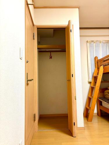 a door leading into a room with a bunk bed at 覚羅中央区別荘101室 in Chiba