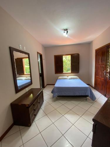 a bedroom with a bed and a dresser and a mirror at Casa em Guaramiranga, ao meio da Natureza! in Guaramiranga