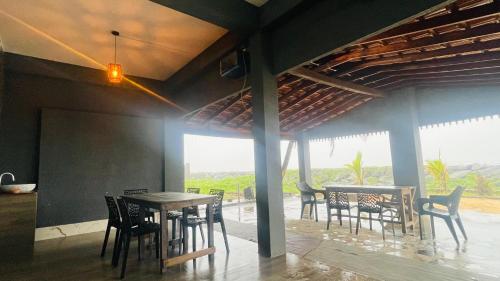 a dining room with tables and chairs and a balcony at Beach at Deltin in Udupi