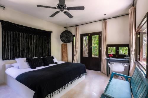 a bedroom with a bed and a ceiling fan at NEST Tulum in Tulum