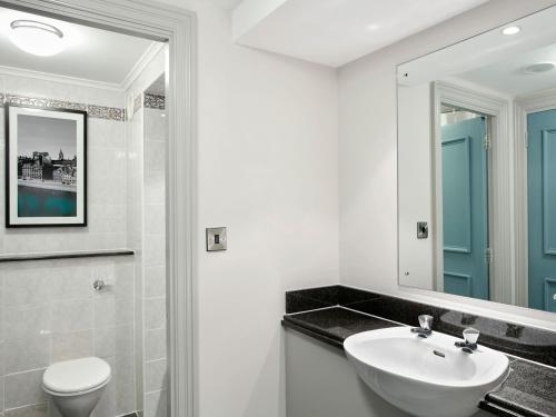 a bathroom with a sink and a toilet and a mirror at Jurys Inn Aberdeen Airport in Dyce