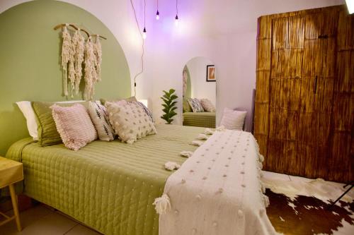 1 dormitorio con cama verde y almohadas rosas en Studio Verdejo - Zona Romantica, en Puerto Vallarta