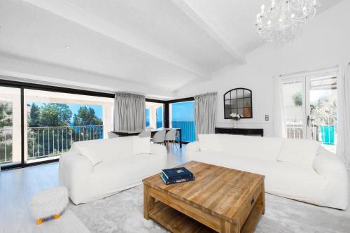 a living room with a white couch and a table at Villa with Panoramic Sea View & Private Pool Roquebrune-Cap-Martin & Monaco in Roquebrune-Cap-Martin