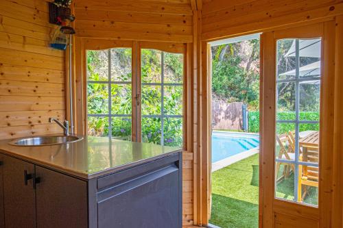 a kitchen with a sink and a view of a pool at Villa with Panoramic Sea View & Private Pool Roquebrune-Cap-Martin & Monaco in Roquebrune-Cap-Martin