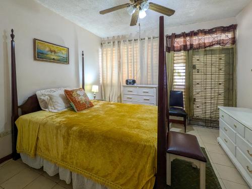 a bedroom with a bed and a ceiling fan at Wellington Manor Townhouse 6 in Liguanea