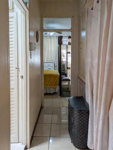a hallway with a room with a bed and a trash can at Wellington Manor Townhouse 6 in Liguanea