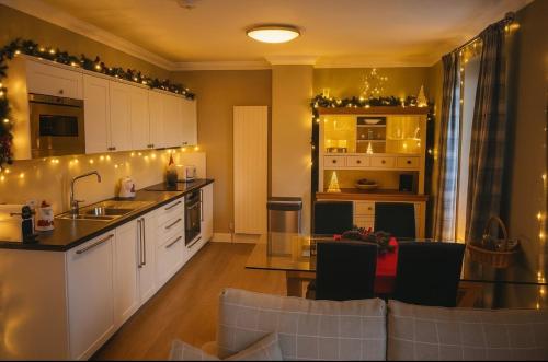 a kitchen with a counter and a table and chairs at Allt Nan Ros Apartments fort william in Onich
