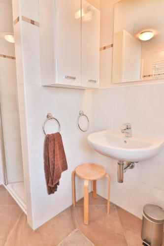a bathroom with a sink and a stool at Strandlust in Langeoog