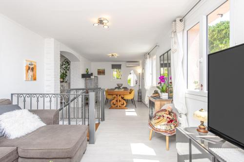 a living room with a couch and a tv at Villa with Panoramic Sea View & Private Pool Roquebrune-Cap-Martin & Monaco in Roquebrune-Cap-Martin