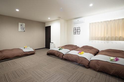 ein Zimmer mit 3 Betten mit Blumen drauf in der Unterkunft Guest House Shine Bright - Vacation STAY 19290 in Fukuoka