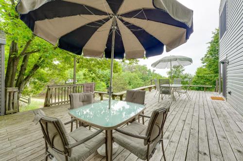 a table and chairs with an umbrella on a deck at Walk to Semi-Private Beach Lake Michigan Getaway in Montague